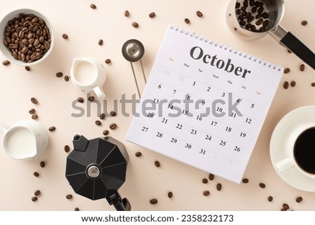 Embrace International Coffee Day with overhead shot of calendar, roasted coffee beans, espresso cup, creamer jars, a coffee pot, a barista's scoop, turk, and kettle, set against pastel beige backdrop