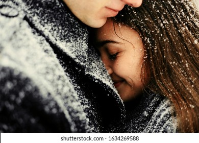 
embrace valentine's day young winter lovers, snow falls on hair and clothes