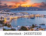 Embrace the warm hues of sunset in Mykonos Town Chora, where the Aegean Sea