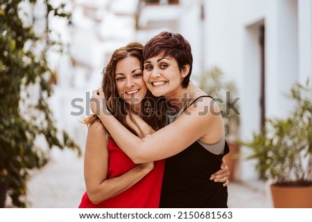 Foto Bild Zwei Frauen umarmt mit Smoothies, die auf die Kamera schauen.