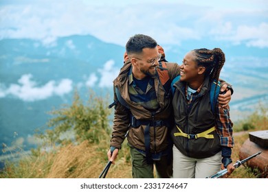 Embraced multiracial couple talking while hiking on a mountain. Copy space.  - Powered by Shutterstock