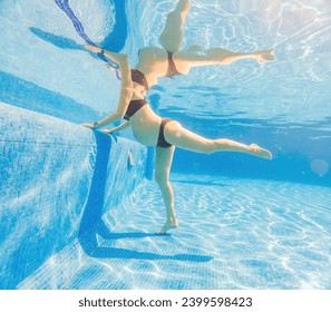 Embracing aquatic fitness, a pregnant woman demonstrates strength and serenity in underwater aerobics, creating a serene and empowering image in the pool - Powered by Shutterstock