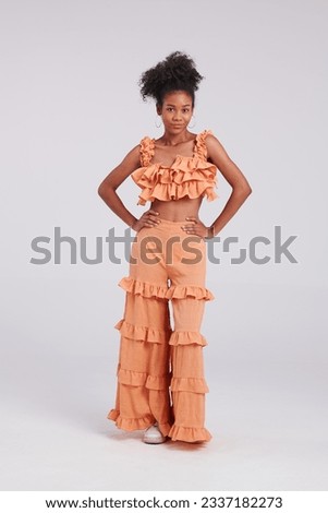 Embracing orange elegance, a Thai American woman exudes style and grace in this studio fashion shoot.