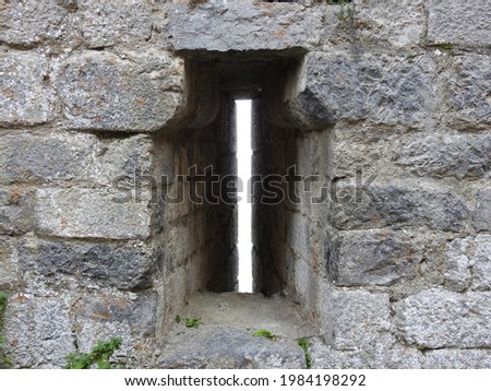 An embrasure (arrowslit) in the keep of Château de Montségur, a ruined fortress and Cathar stronghold during the Albigensian Crusade. Ariège, Occitanie, southwestern France