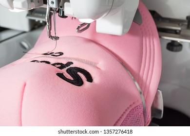 Embroidered Pink Cap On Hoop Of Embroidery Machine Close Up Image