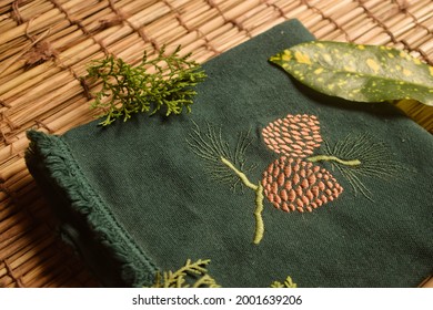 Embroidered towel of Christmas season. Conifer cone motif is used.