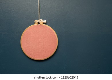 Embroidery Frame Hanging On Navy Wall With Copy Space.