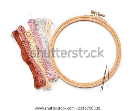 Embroidery hoop with mouline threads and needles isolated on white background