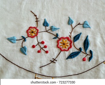 Embroidery pattern on batiste napkin. Abstract flowers on white background. Art and craft conception, closeup