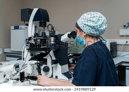 Embryologist adding sperm to egg in laboratory of reproductive clinic. in vitro fertilization, egg freezing. injects one sperm into each egg by microinjection. intracytoplasmic Sperm injection. imsi