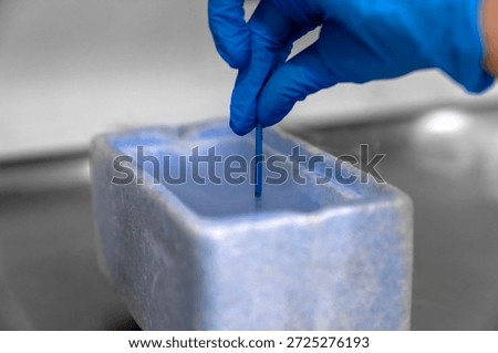 Embryologist in blue gloves using liquid nitrogen for cryopreservation of embryos and eggs in IVF lab, vitrification process in fertility clinic for assisted reproductive technology and pregnancy.