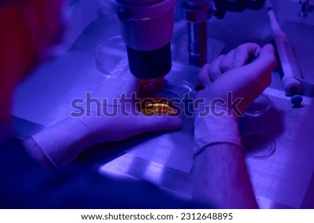 Embryologist checking state of embryos in petri dish