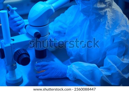 Embryologist uses the micromanipulator set to perform ICSI procedure