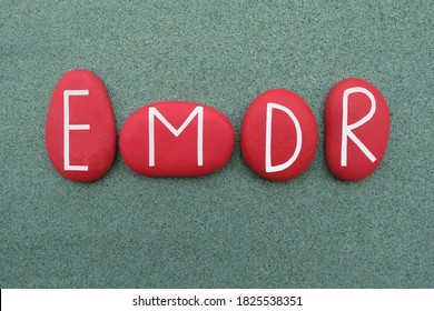 EMDR, Eye Movement Desensitization and Reprocessing, creative text composed with red colored stone letters over green sand - Shutterstock ID 1825538351