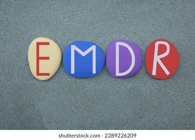 EMDR, Eye Movement Desensitization and Reprocessing, creative text composed with multi colored stone letters over green sand - Shutterstock ID 2289226209