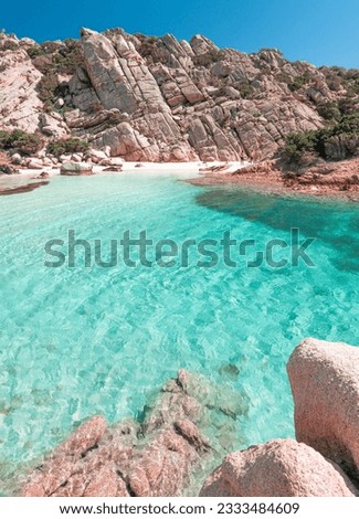 The emerald blue water in contrast with the pink granite of Cala Napoletana on the island of Caprera part of the archipelago of La Maddalena in northern Sardinia