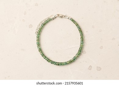 Emerald bracelet. Bracelet made of stones on hand from natural stone Emerald. Bracelet made of natural stones. Handmade jewelry. Handmade bracelets on light modern background.