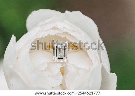 Emerald cut engagement ring inside a white flower. 4 carats with a gold band. 