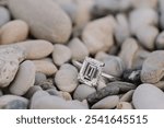 Emerald cut engagement ring sitting in the rocks