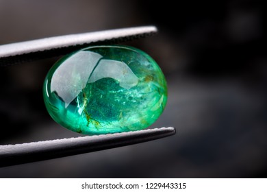 The emerald gemstone jewelry photo with dark lighting background.