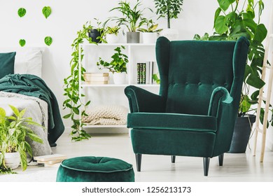 Emerald Green Comfortable Armchair And Pouf In Contemporary Bedroom Interior With Urban Jungle