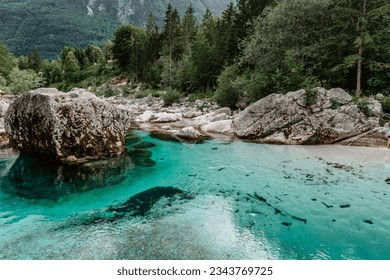 Emerald turquoise water of Soca river in Slovenia.Rafting and kayaking place in Europe. Wonderful Soca gorge in green forest near Bovec.Summer outdoor activities.Crystal clear water