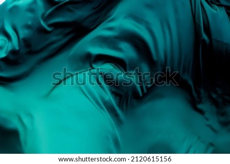 emerald-colored satin fabric in waves and pleats