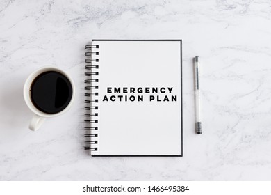 Emergency Action Plan Writing On Notebook. Notebook On Desk With Coffee Cup And A Pen.