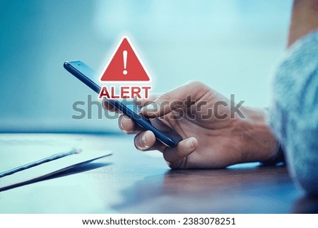 Emergency alert security message pop up on phone screen. Woman hand holding smartphone while receiving an official emergency alert notification from government. 