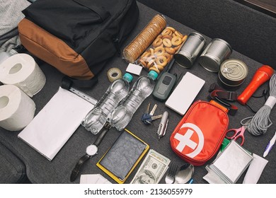 Emergency Backpack Equipment Organized On The Table. Documents, Water,food, First Aid Kit And Another Items Needed To Survive.