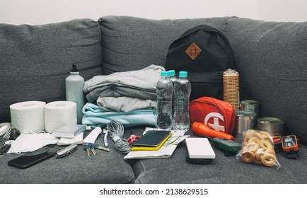 Emergency Backpack Equipment Organized On The Table. Documents, Water,food, First Aid Kit And Another Items Needed To Survive.