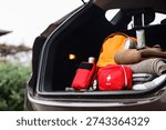 Emergency backpack, first aid kit and necessities in trunk of car outdoors, closeup