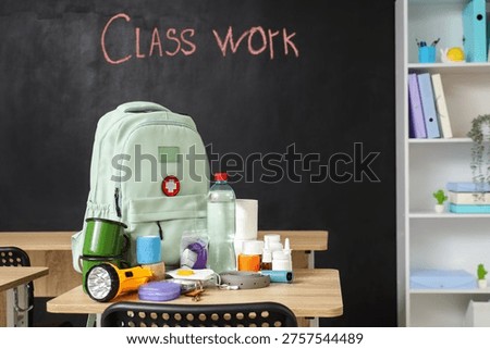 Emergency backpack and necessities on table in empty classroom