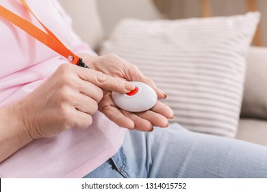 Emergency call system. Senior woman pressing Alarm Button, closeup