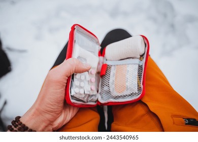 Emergency care with the use of a first aid kit, bushcraft in the winter forest, survival alone, pills for pain and nausea. Travel First Aid Kit. High quality photo - Powered by Shutterstock