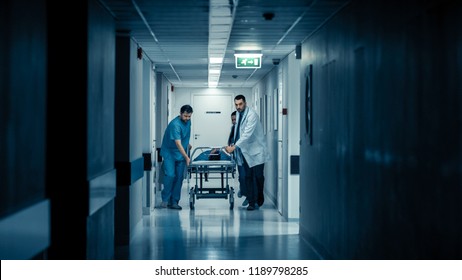 Emergency Department: Doctors, Nurses And Paramedics Run And Push Gurney / Stretcher With Seriously Injured Patient Towards The Operating Room. Bright Modern Hospital With Professional Staff.