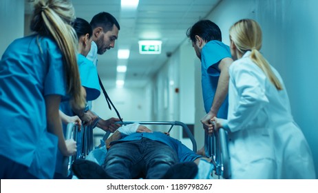Emergency Department: Doctors, Nurses and Surgeons Move Seriously Injured Patient Lying on a Stretcher Through Hospital Corridors. Medical Staff in a Hurry Move Patient into Operating Theater. - Shutterstock ID 1189798267