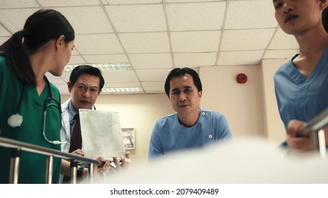 Emergency Department. Nurse And Senior Doctor Team Busy Push Emergency Stretcher Transport Senior Patient In Hospital, Doctors, Nurses In Surgical Gown And White Coat Uniform Running With Hurry