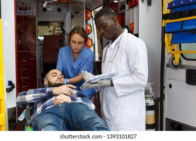 Emergency Doctor Asking Patient To Sign In Logbook At Ambulance Car