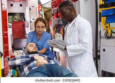 Emergency Doctor Asking Patient To Sign In Logbook At Ambulance Car