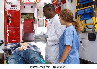 Emergency Doctor Asking Patient To Sign In Logbook At Ambulance Car