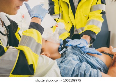 Emergency doctor giving cardiac massage for reanimation in ambulance to woman