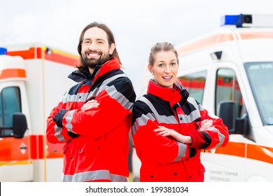 Emergency doctor and nurse standing in front of ambulance 