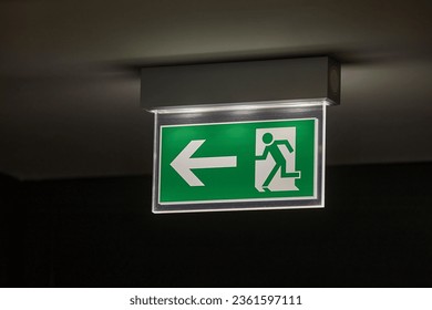 Emergency exit sign glowing in the dark - Powered by Shutterstock