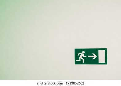 An emergency exit sign on a white wall