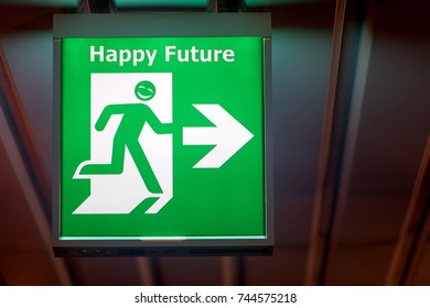 The Emergency Exit Sign Shows The Direction Of Escape In Case Request Of Happy Future. The Board For Wish Of Lucky Hangs On The Ceiling Of The Building.