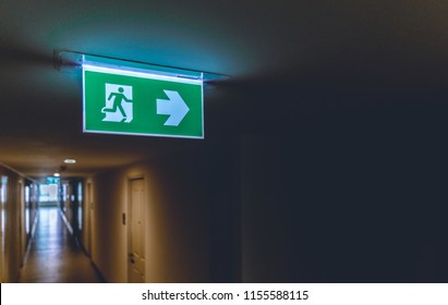 Emergency Fire Exit Green Sign At The Corridor In Office Building., Close Up At The Signs.