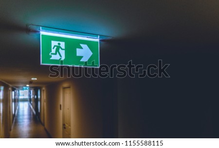 Emergency fire exit green sign at the corridor in office building., close up at the signs.