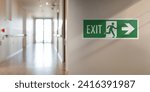 Emergency fire exit sign in the corridor of the school. Arrow on the right, blurred background with copy space for text and messages.