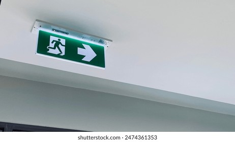 Emergency fire exit sign direction to doorway in the building green color and narrow. - Powered by Shutterstock